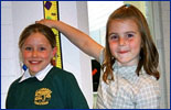 Two children measuring their height